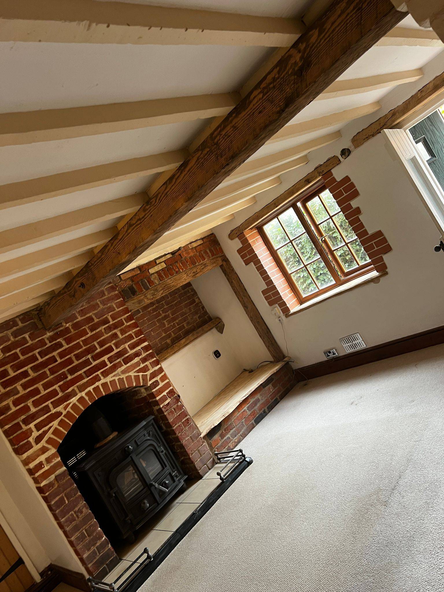 Restored fireplace room with exposed beams