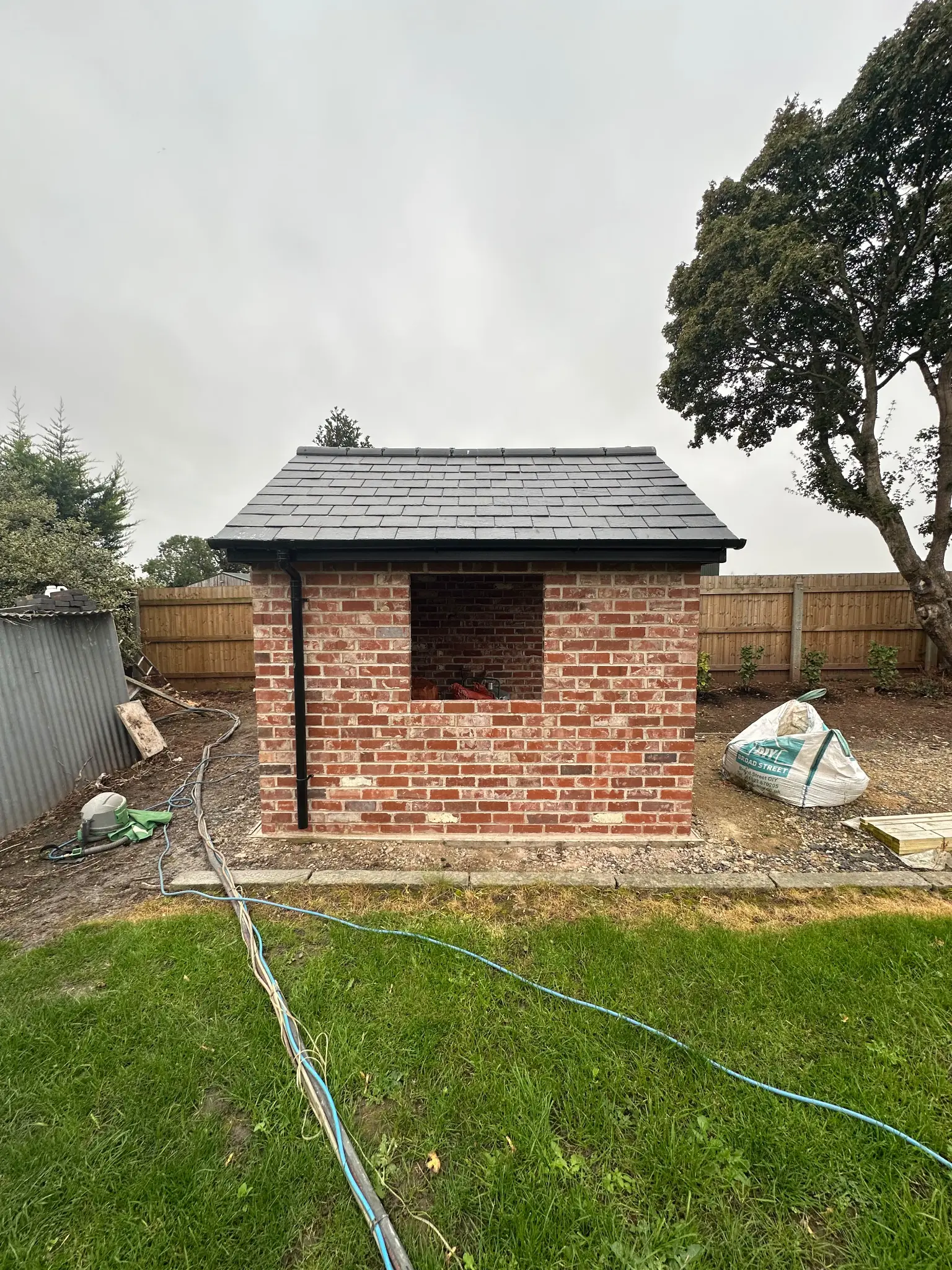 Rear brick elevation of a garden outbuilding before surface cleaning