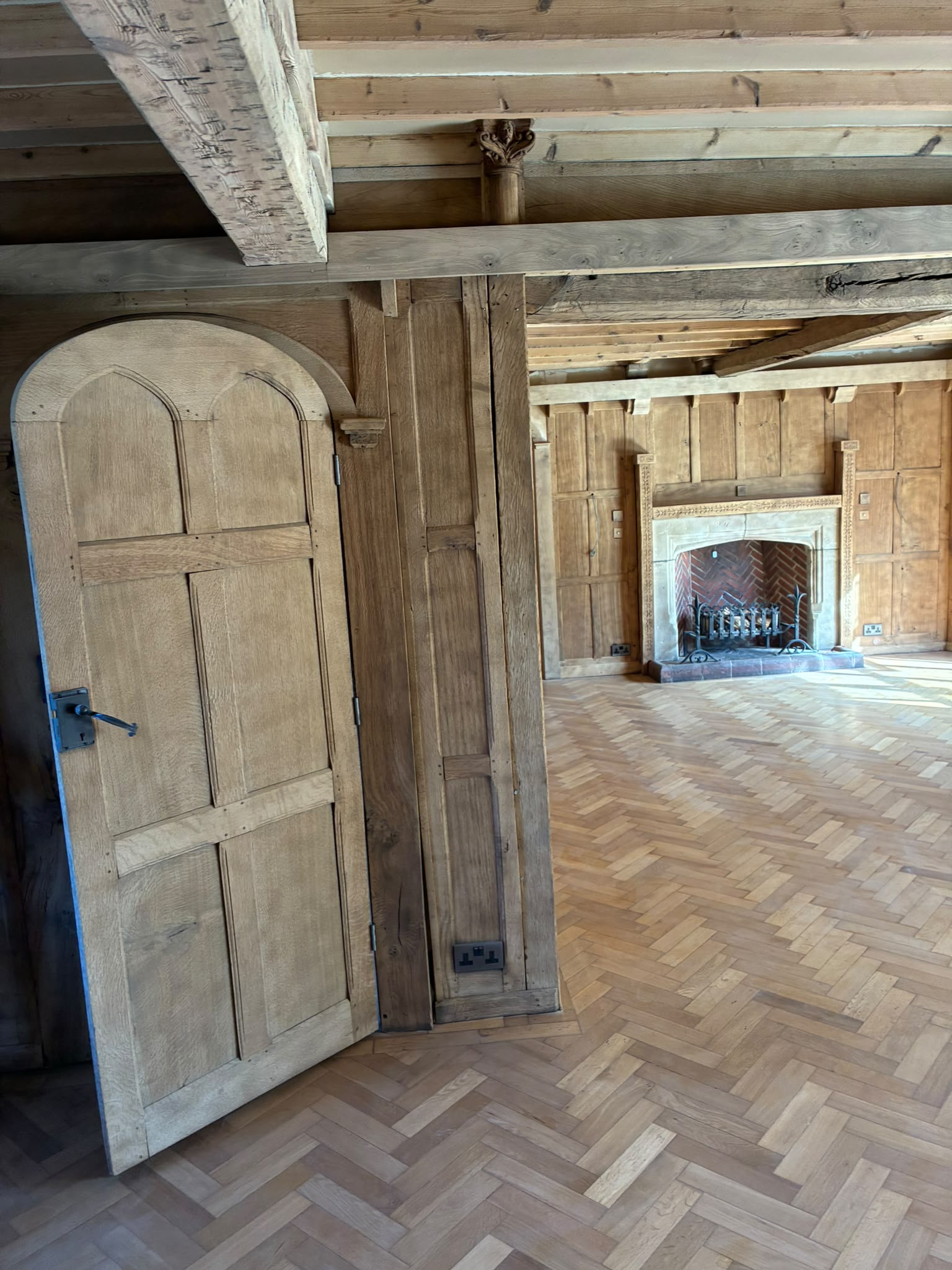 Grand Hall living area with lighter exposed beams and panelling after restoration