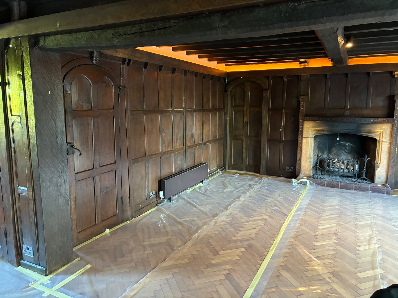 Grand Hall living area with dark timber panelling before restoration