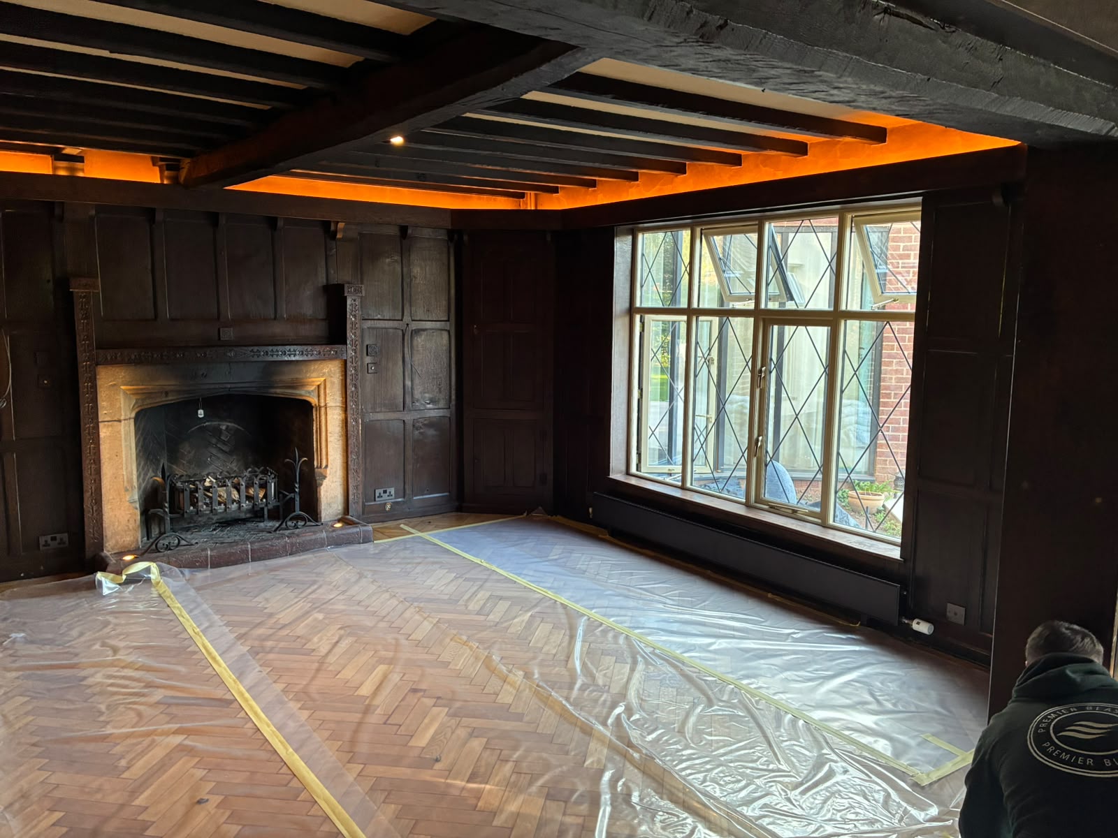 Grand Hall living area with dark ceiling beams and panelling before restoration