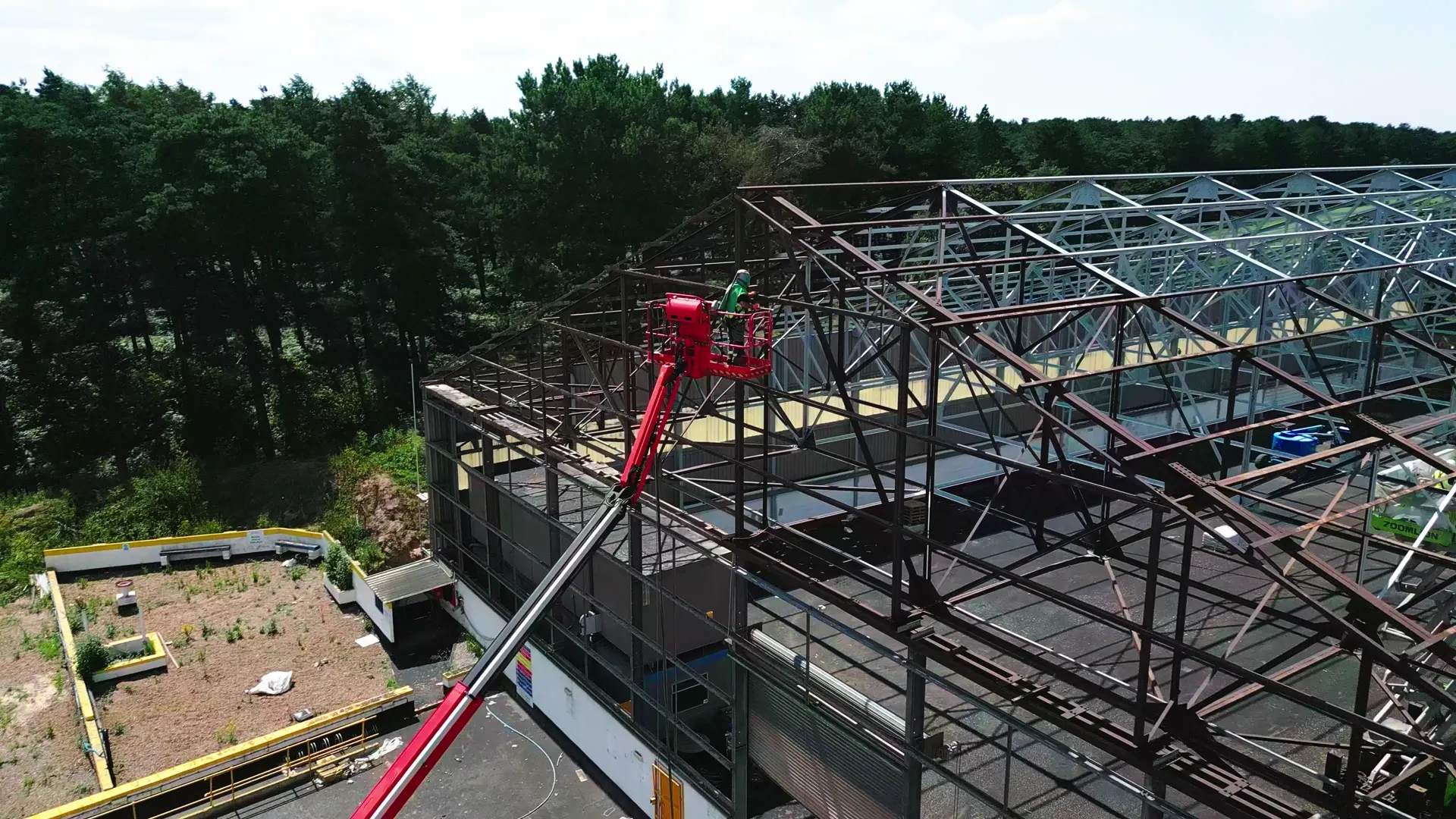Operator in protective equipment carrying out blasting work on steelwork