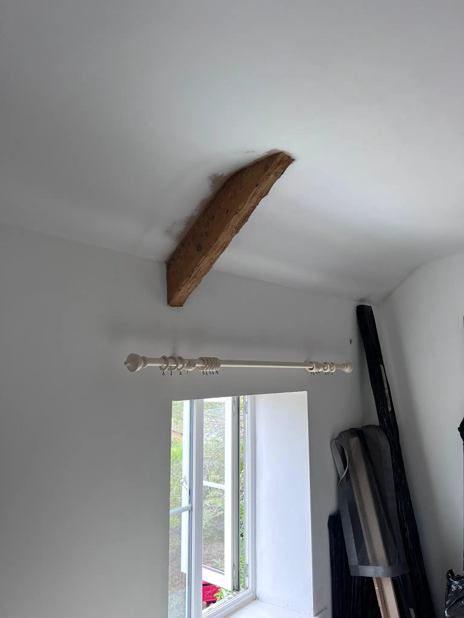 Lighter exposed ceiling beam above a window after restoration